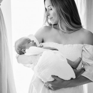 Black and white photo of Jordan holding her baby in her arms.