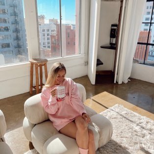 Jordan sitting on a large armchair in a bright living room.