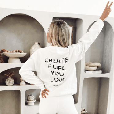 Jordan wearing a white sweatshirt that says "Create a Life You Love".