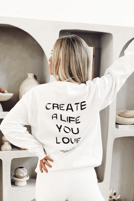Jordan wearing a white sweatshirt that says "Create a Life You Love".