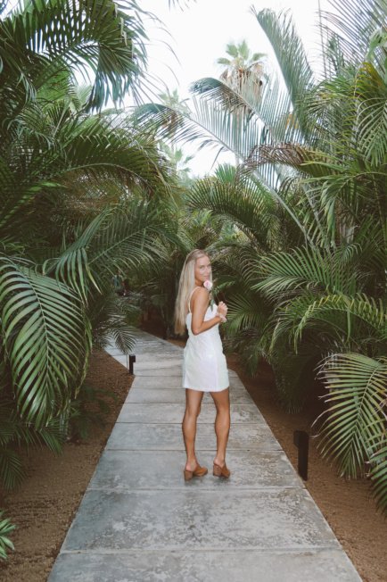 Jordan walking down a path in a tropical place.